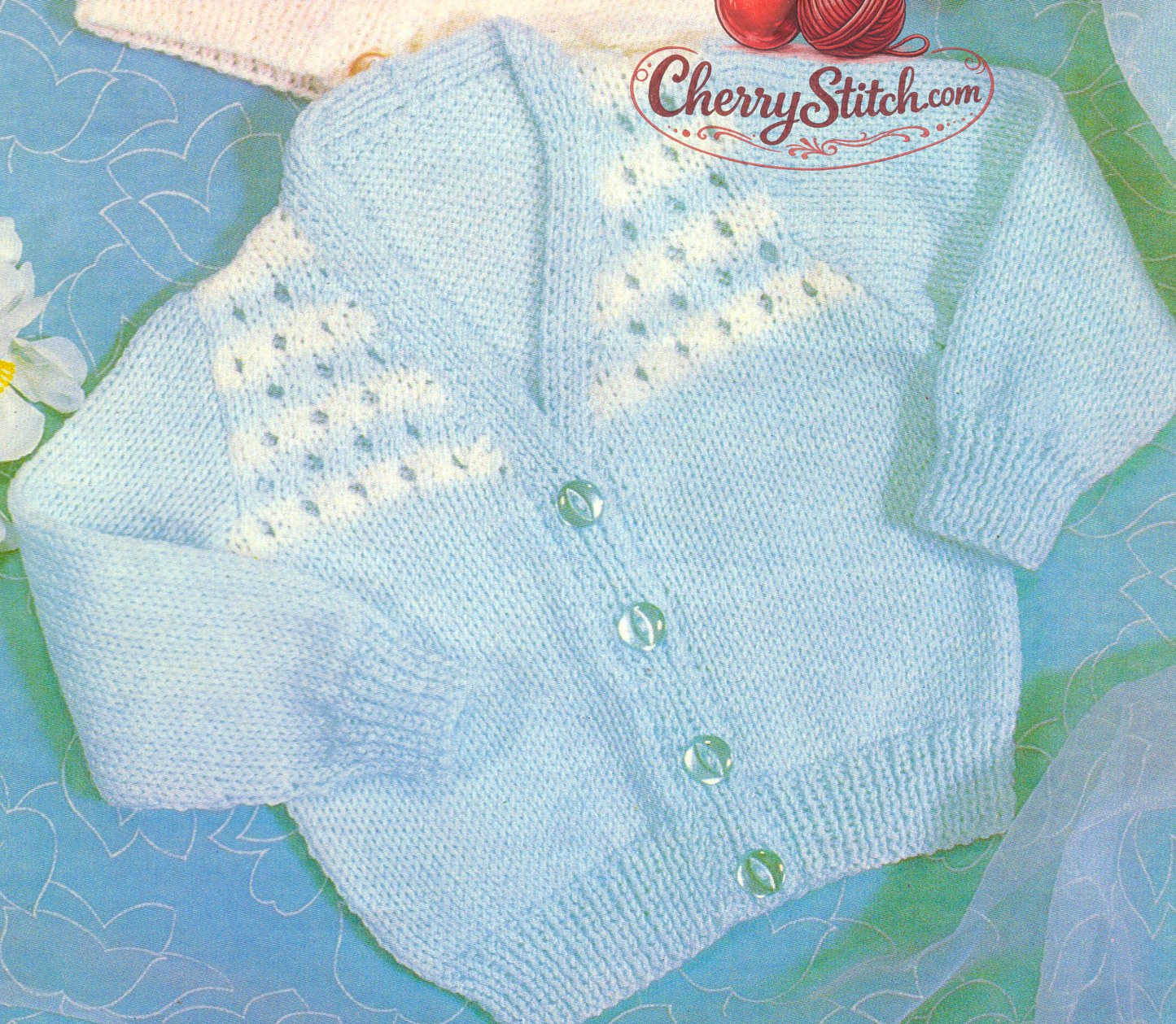 Close-up of eyelet lace front yoke – restored vintage 1970s baby raglan V-neck cardigan knitting pattern in DK
