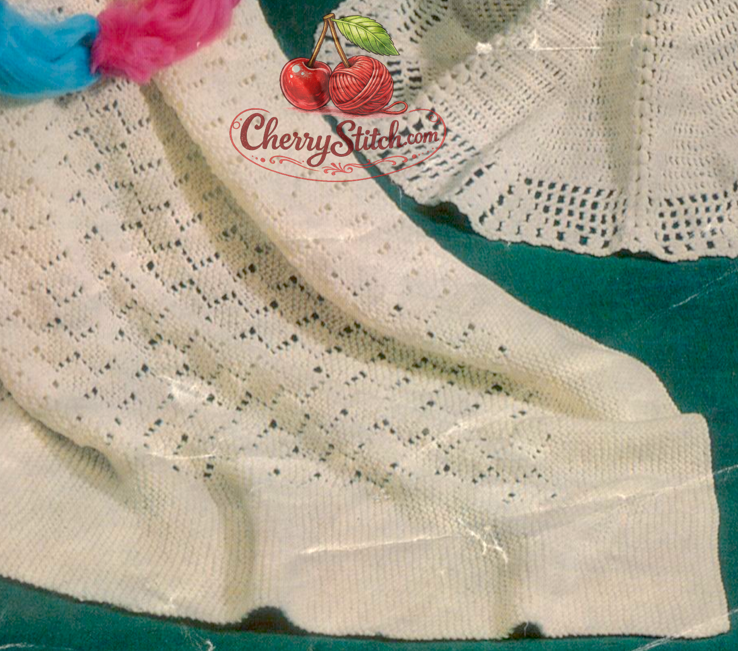 Close-up of knitted baby square shawl in diamond lace stitch with garter stitch borders. Restored vintage 1960s pattern in DK, worked in one piece, 44''.