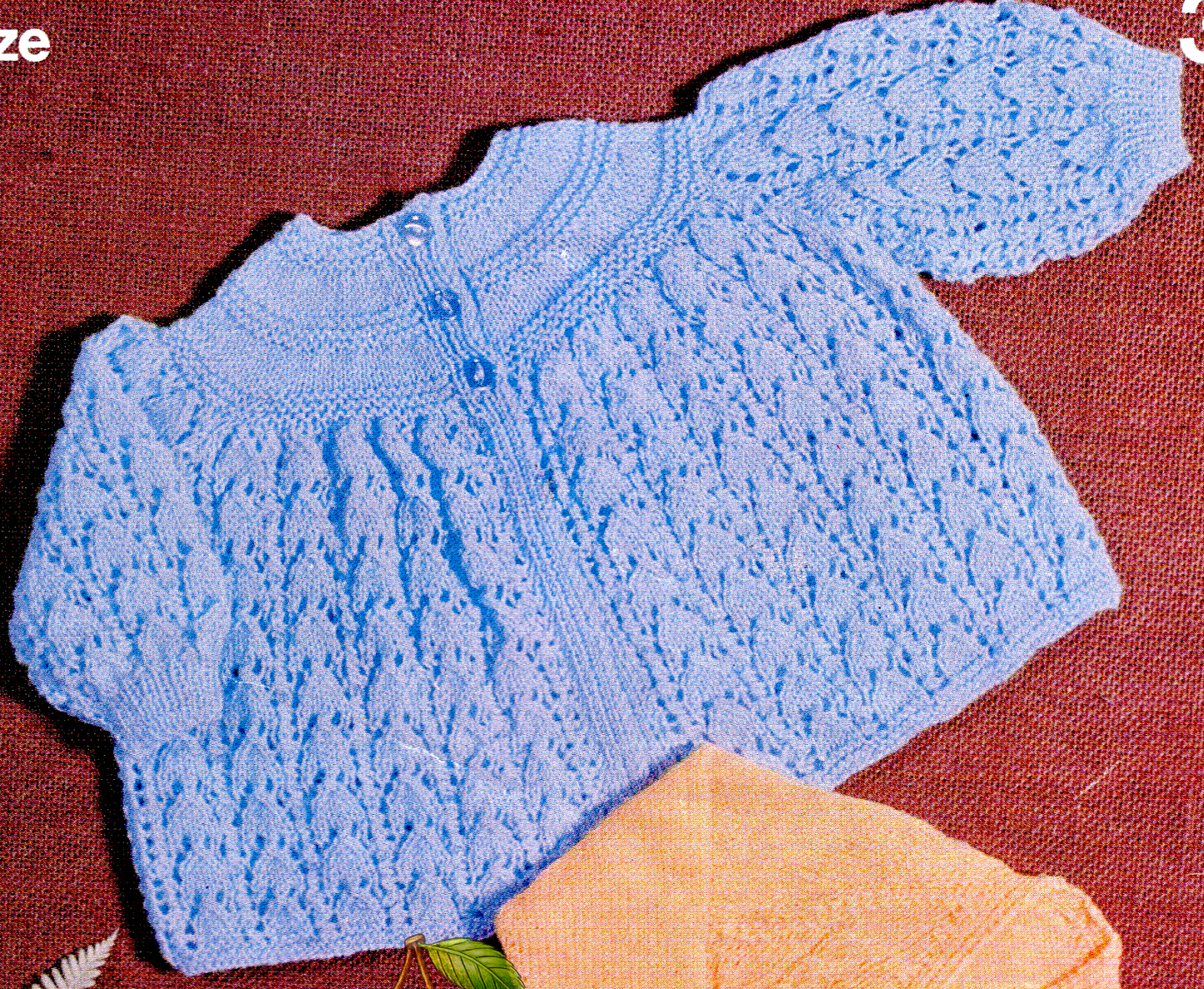 Close-up of blue baby matinee coat with neat yoke and delicate lace panel in the skirt. Restored vintage 1960s knitting pattern in 3-ply.