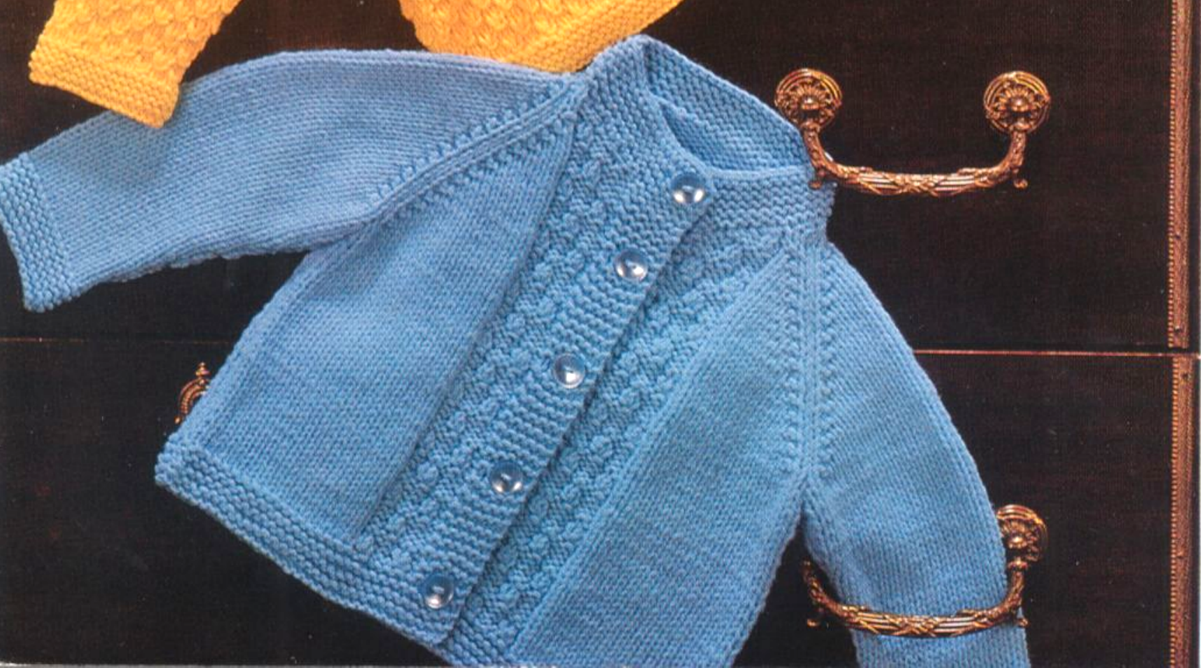 Close-up of blue knitted baby raglan jacket – restored vintage 1980s textured stitch pattern