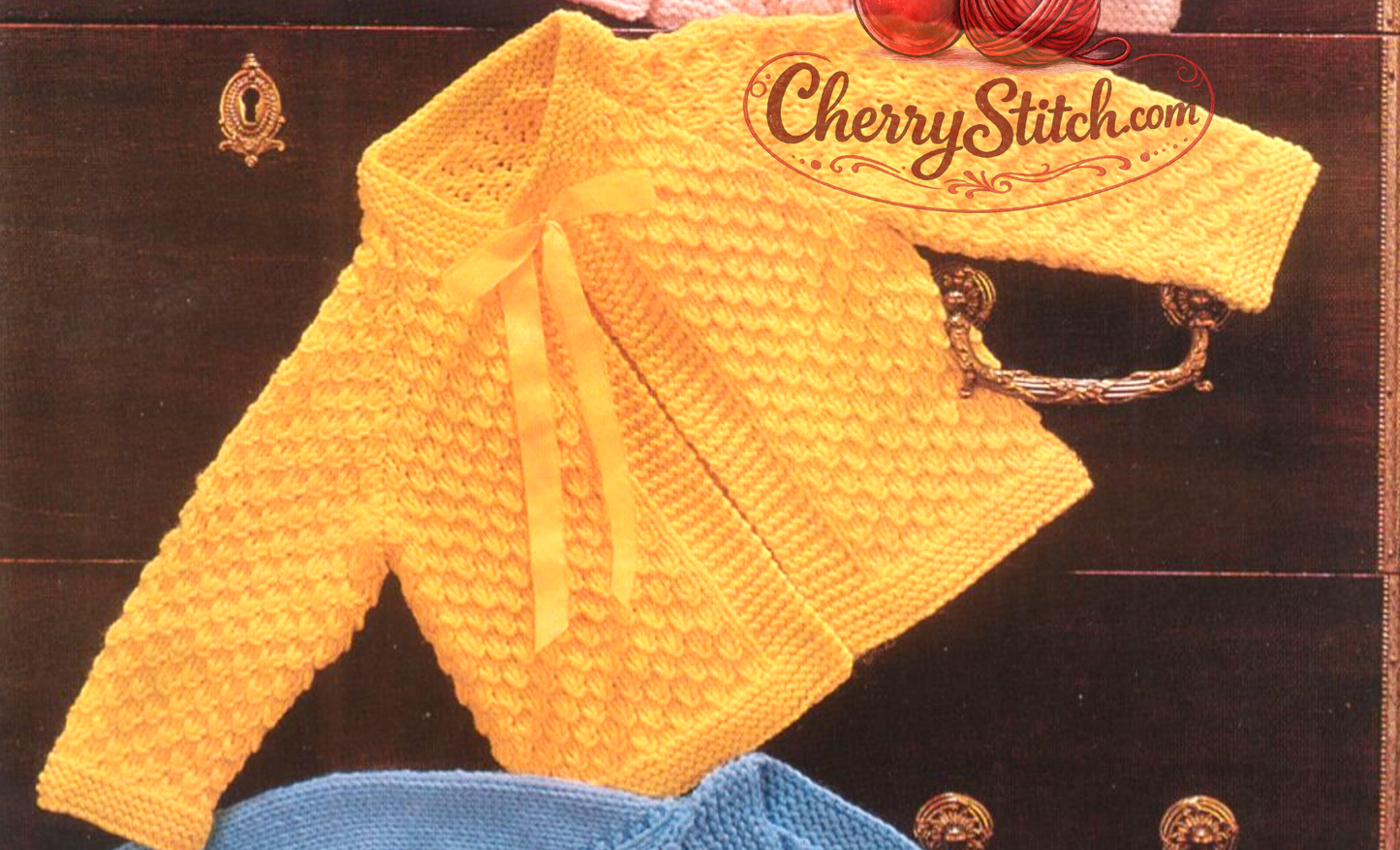 Close-up of yellow knitted baby raglan jacket – restored vintage 1980s textured stitch pattern