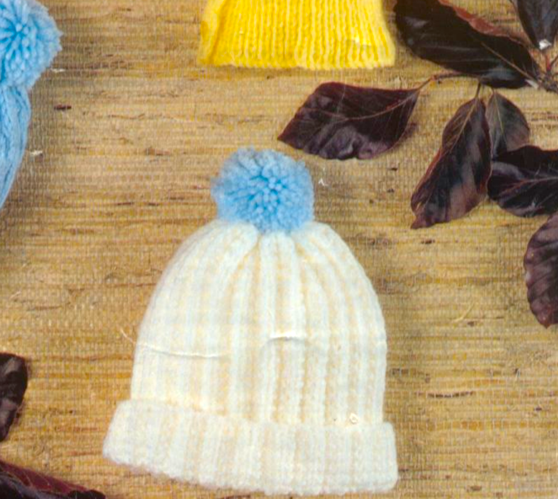 Close-up of white knitted baby pull-on hat in moss rib – restored vintage 1980s boys hats knitting pattern