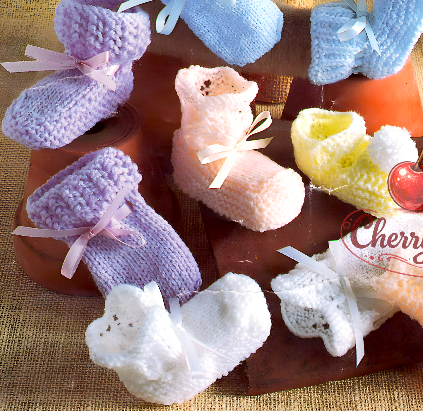 Close-up of knitted baby shoes and bootees – restored vintage 1990s 6 sets knitting pattern