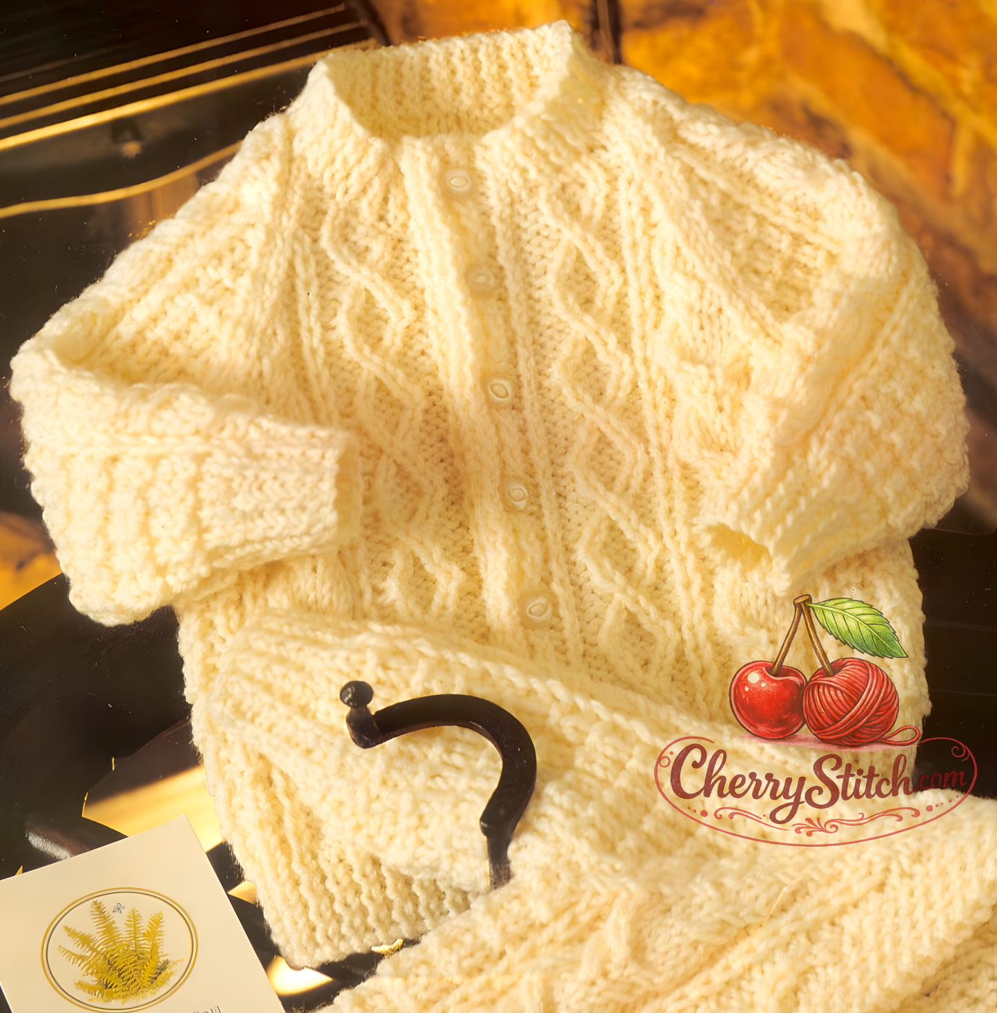 Close-up of cable panels on button-to-neck Aran style baby cardigan – restored vintage 1980s raglan knitting pattern in DK