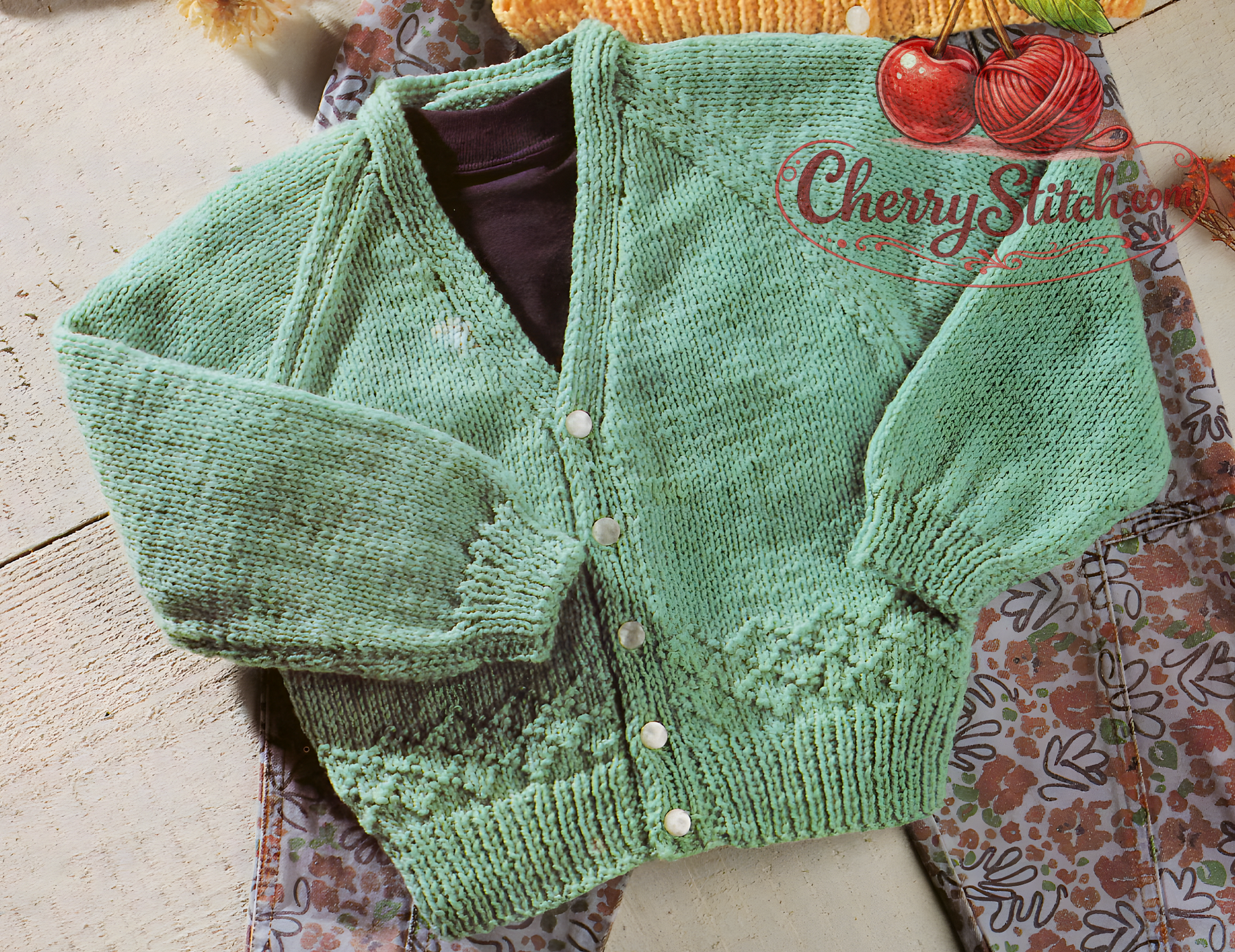Close-up of baby V-neck cardigan – vintage 1980s raglan knitting pattern DK