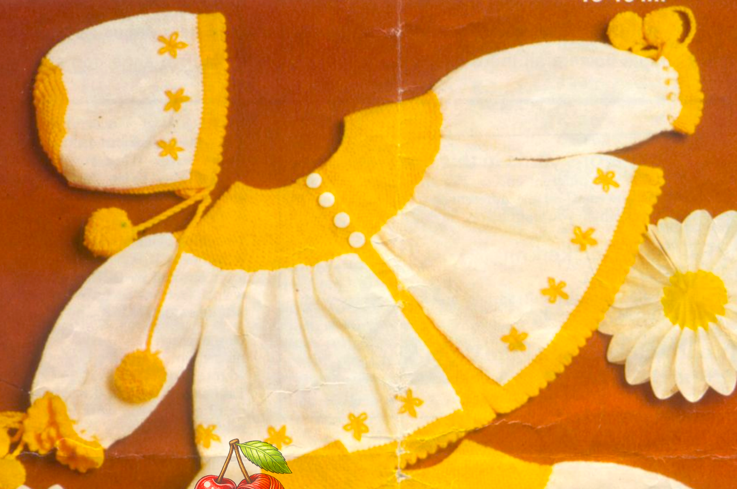 Close-up of matinee coat and bonnet with golden yellow yoke contrast and lazy daisy embroidery – restored vintage 1970s baby layette knitting pattern in 4-ply