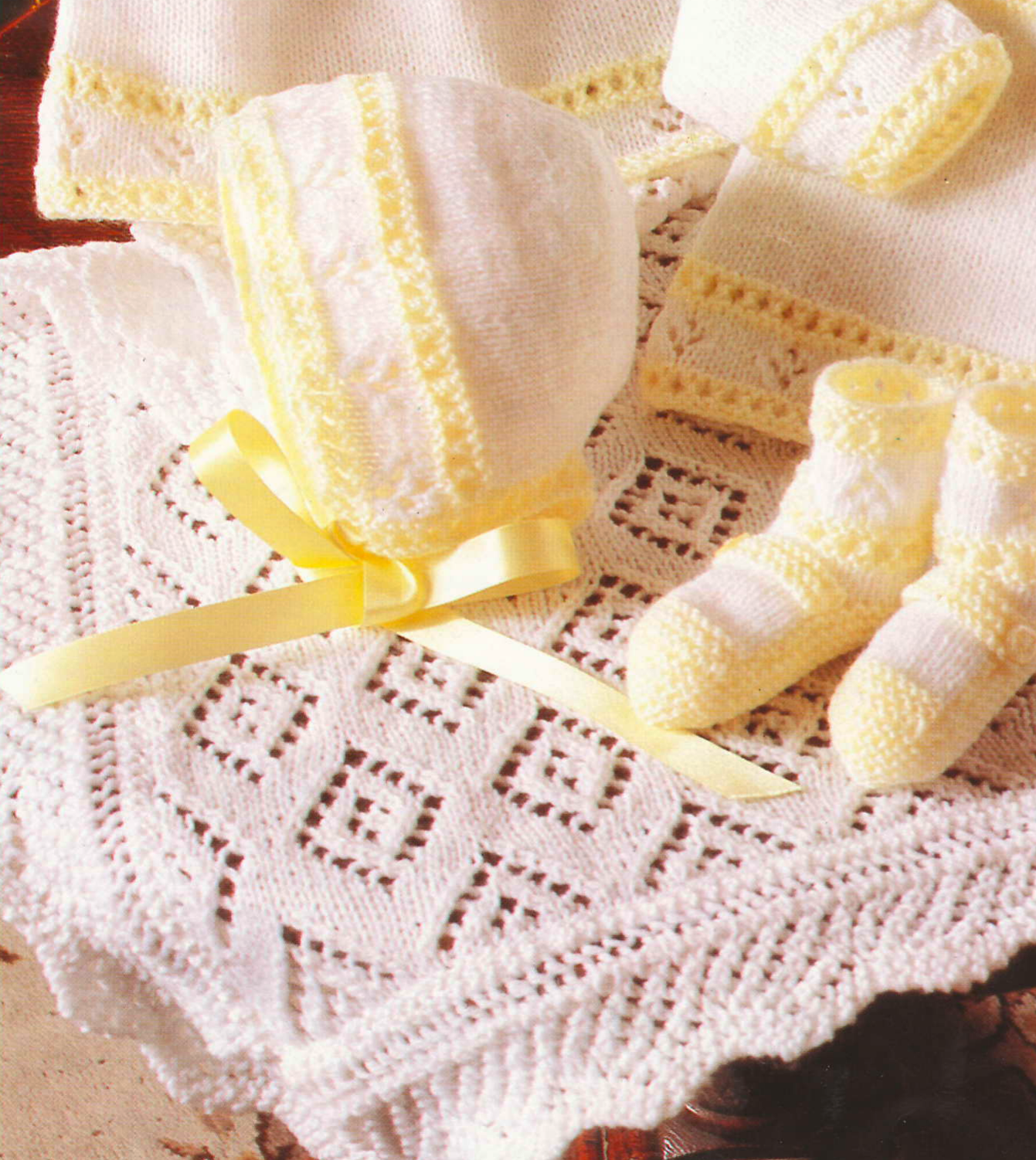 Close-up of knitted baby girl lacy diamond shawl and bonnet – restored vintage 1980s layette pattern in 4-ply