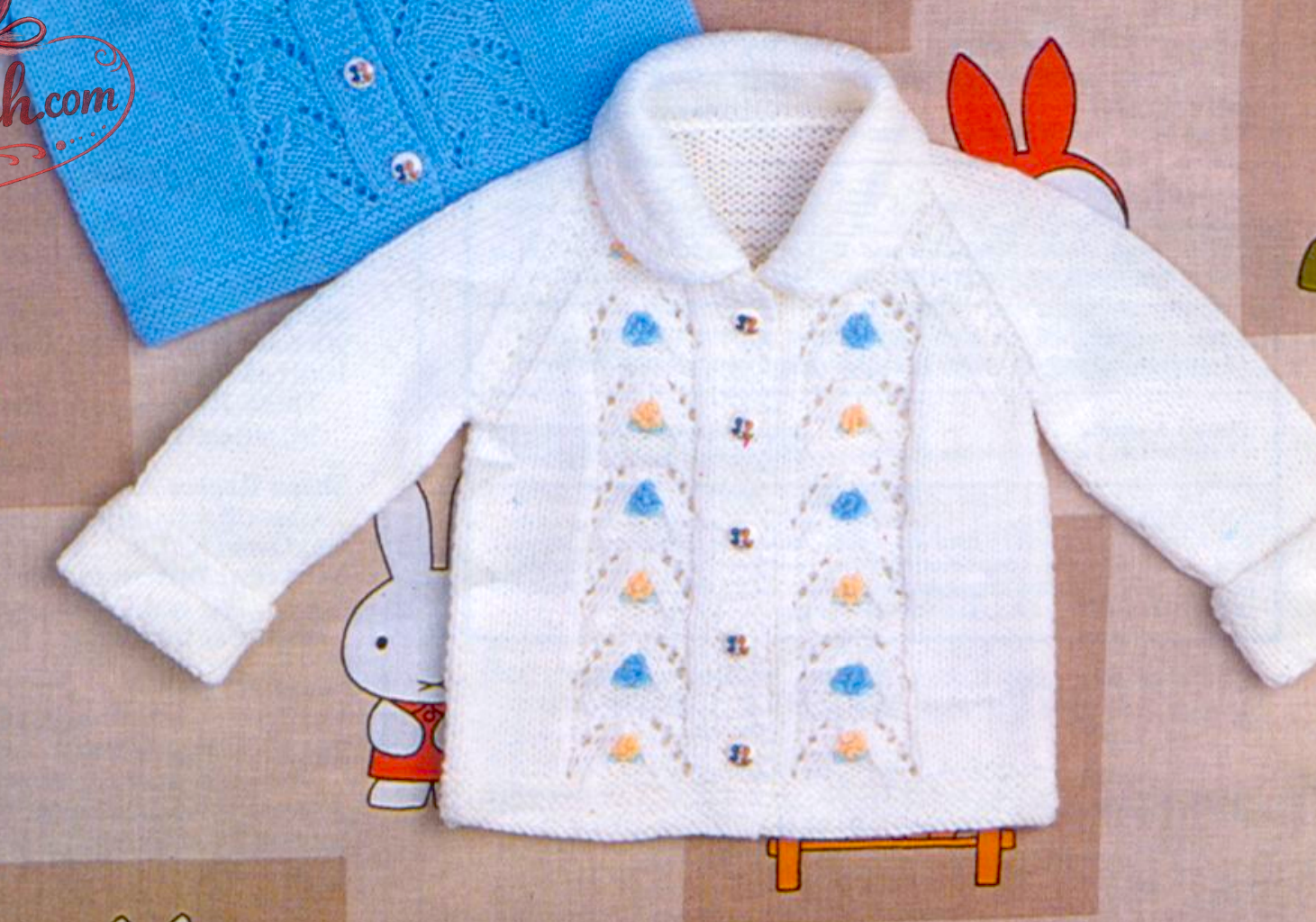 Close-up of white knitted baby raglan jacket with lacy panels and rounded collar – restored vintage 1980s pattern