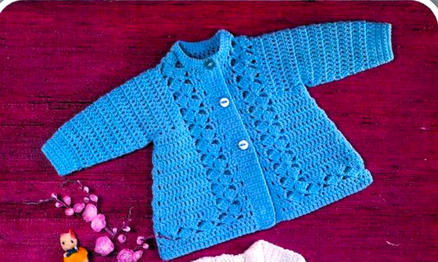 Close-up of blue baby matinee coat from vintage 1980s crochet pattern, showing treble crochet and shell stitch in more detail