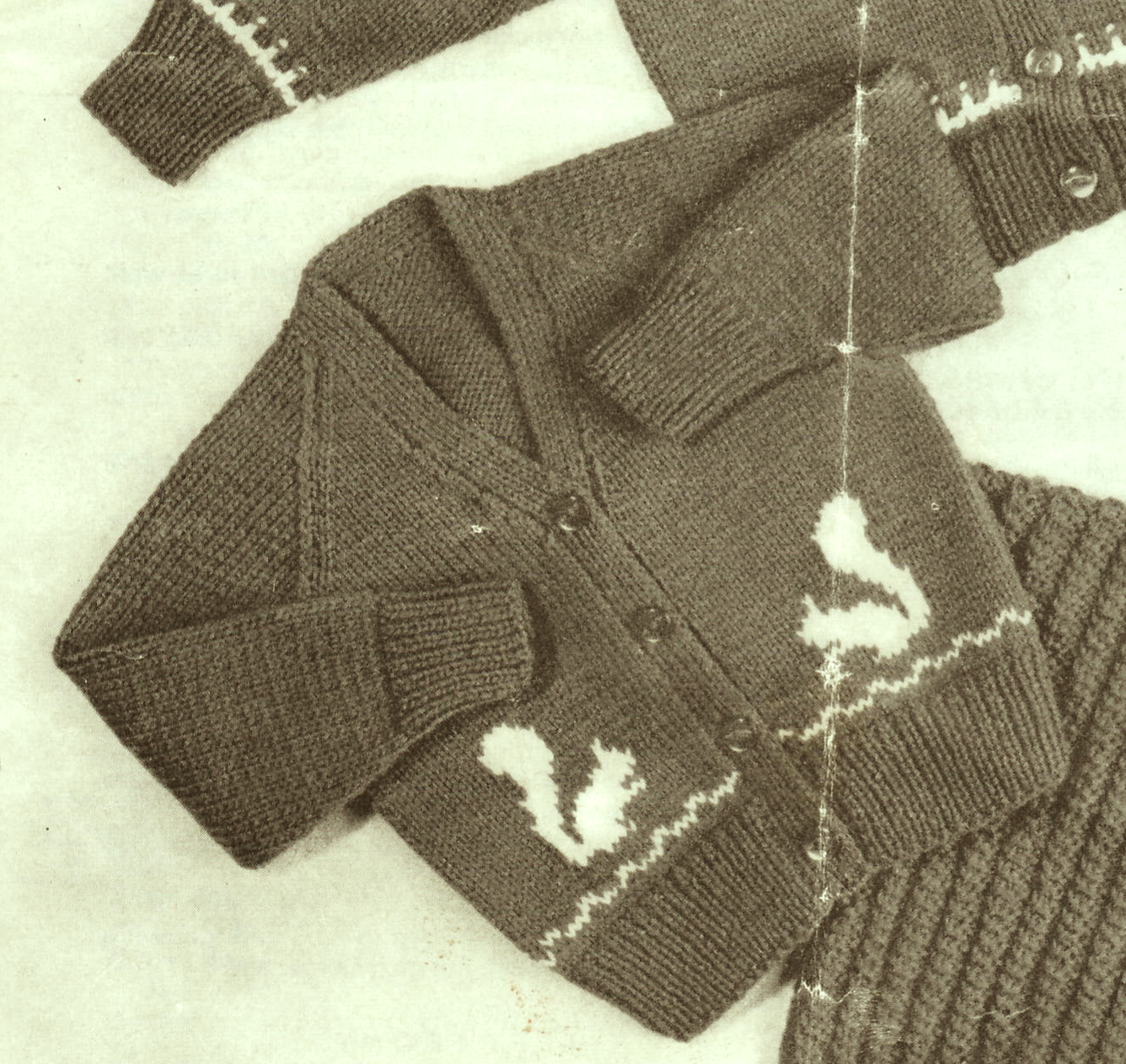 Close-up of V-neck cardigan with squirrel motifs on front and back – restored vintage 1950s baby toddler knitting pattern in DK