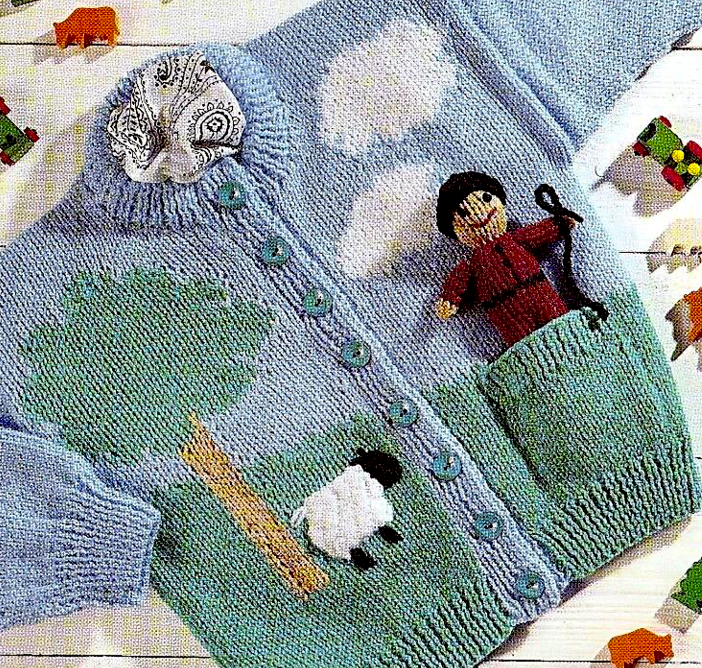 Close-up of knitted child's farmer intarsia cardigan front with tree, sheep and clouds – restored vintage 1980s pattern